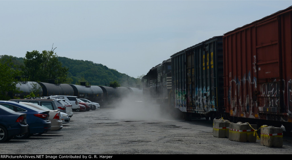 Discharge of air kicks up a little dust as NS E19 and CSX grain/ethanol combo rolls by